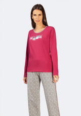 Magentafarbenes, langärmeliges Sweatshirt mit weißem Text und perlenartiger Borte am Halsausschnitt.