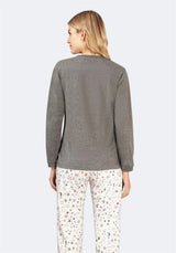 Grauer strukturierter Pullover mit weißer Hose mit Sternenmuster.