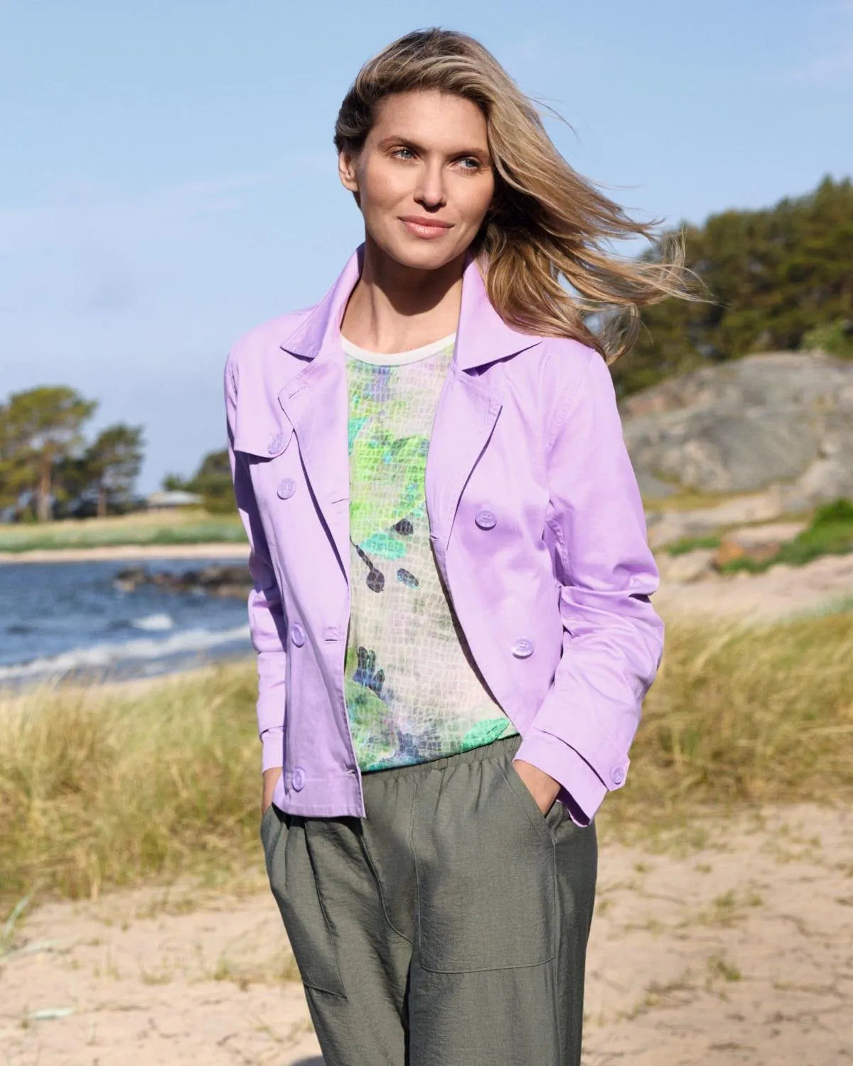 Lavendelfarbener Baumwollblazer mit grünem Hemd mit Blumenmuster und olivfarbener Hose.