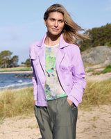 Lavendelfarbener Baumwollblazer mit grünem Hemd mit Blumenmuster und olivfarbener Hose.