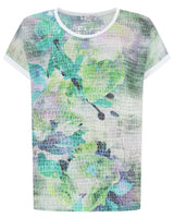 T-Shirt aus geblümtem Netzstoff in Grün- und Lila-Tönen, kurze Ärmel, weißer Saum am Ausschnitt.