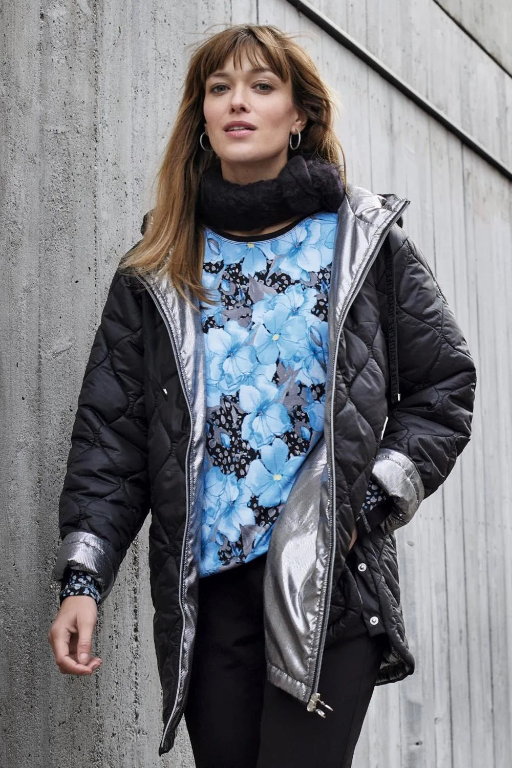 Schwarz-silberne, gesteppte Pufferjacke mit Metallic-Akzenten.