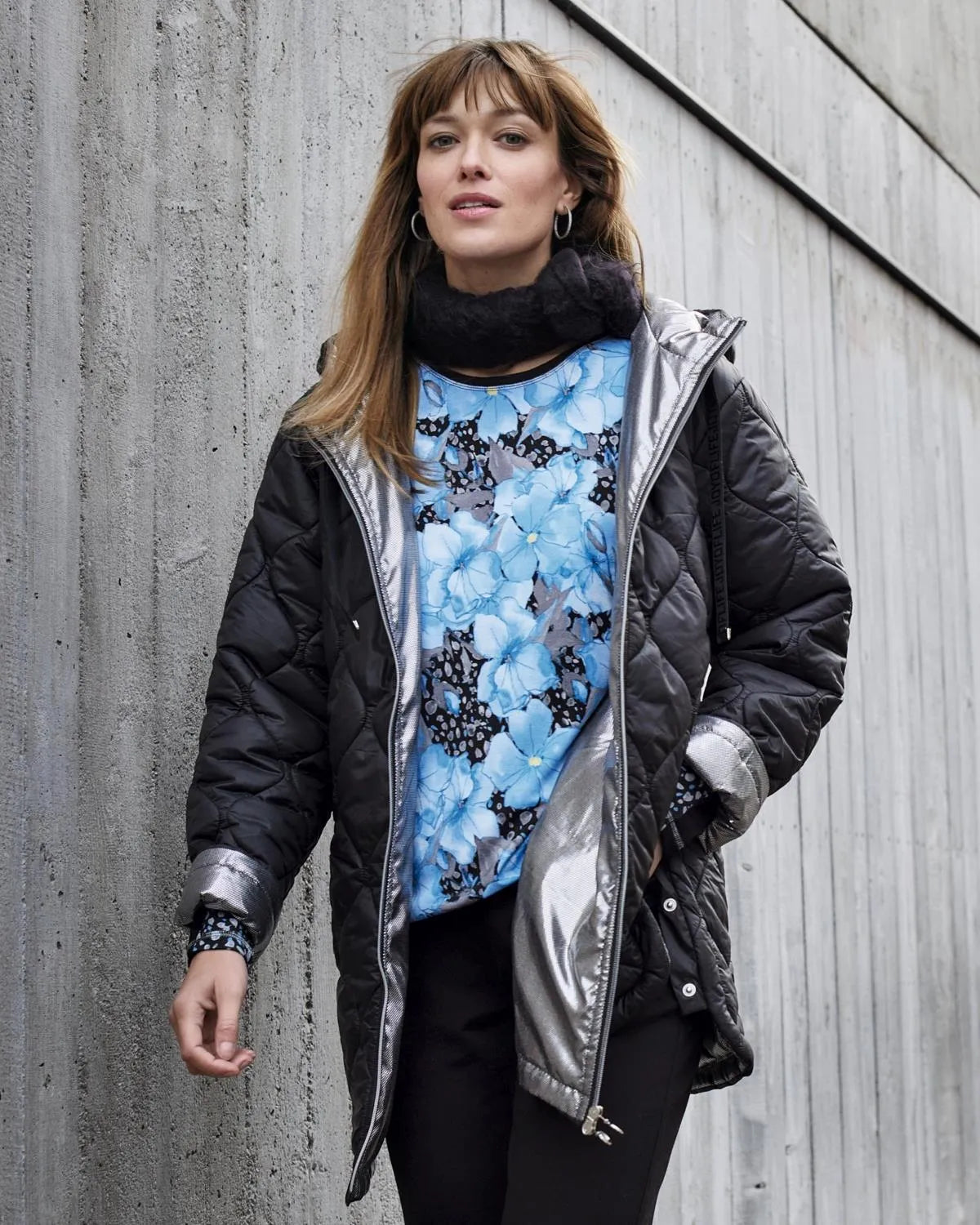 Schwarz-silberne, gesteppte Pufferjacke mit Metallic-Akzenten.