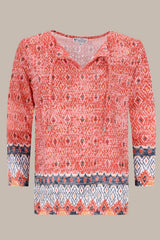 Korallen- und marineblau gemusterte Bluse mit V-Ausschnitt.