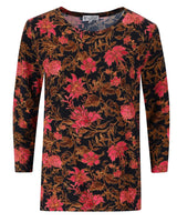 Langärmeliges Kleid mit Blumendruck, schwarzem Hintergrund und rosa Blumen.