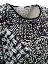 Schwarz-weiß gemusterter Pullover mit texturierter Gestaltung, wahrscheinlich aus Baumwolle oder Polyester-Mischung gefertigt.