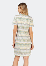 Weißes und grünes Kleid mit Zickzackmuster und geschlitztem Saum, wahrscheinlich aus Baumwolle oder Polyester.