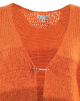 Orangefarbene, strukturierte Strickjacke mit Sicherheitsnadelverschluss.