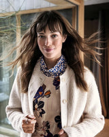 Cremefarbene Zopfstrickjacke mit Hemd mit Blumenmuster und gemustertem Schal.