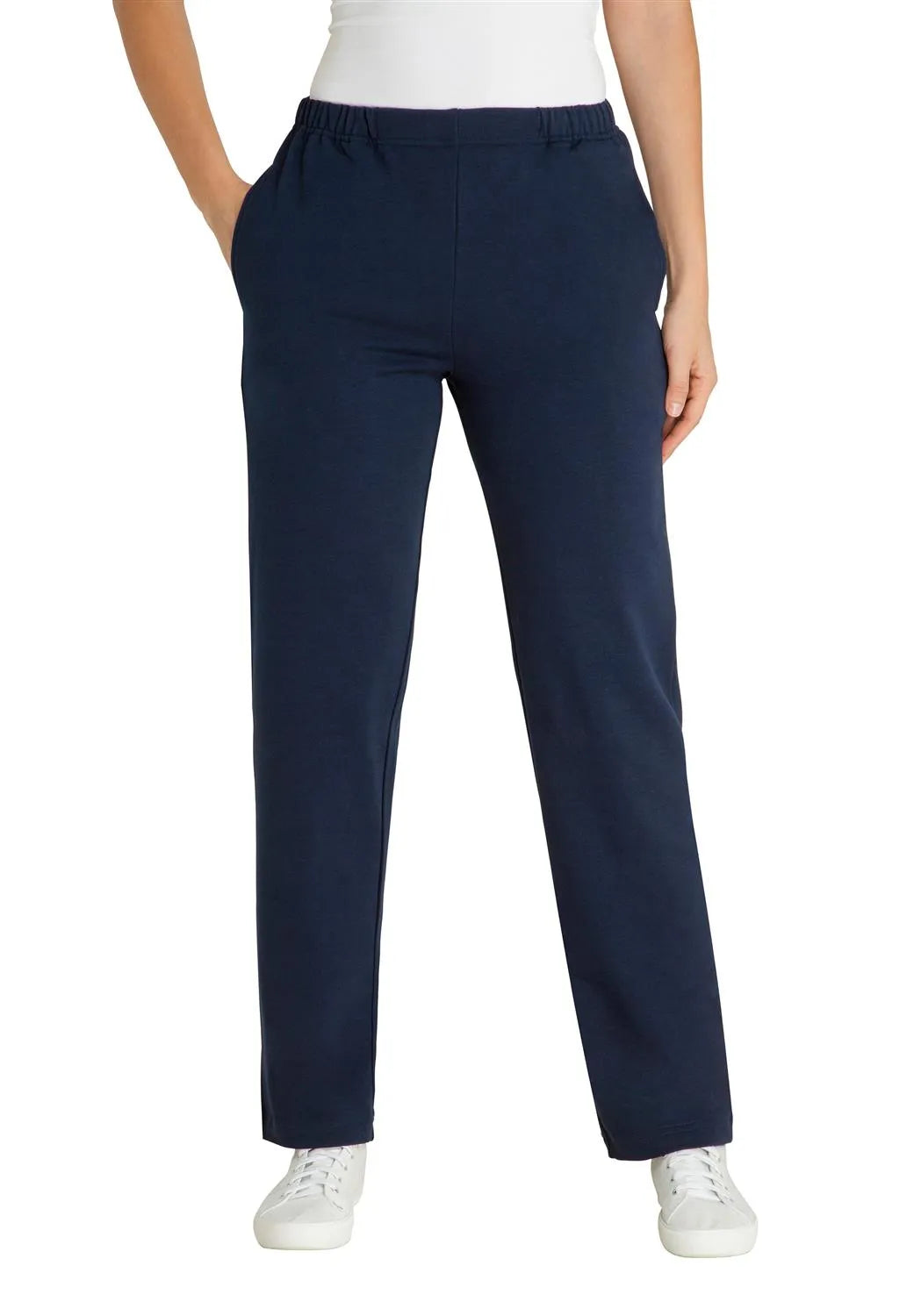 Marineblaue Stretch-Hose mit weißen Turnschuhen und einem weißen Oberteil.
