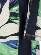 Leggings mit Blumenmuster, grünen Blättern und weißen Blumen auf dunklem Hintergrund, aus dehnbarer Stofffabrik.
