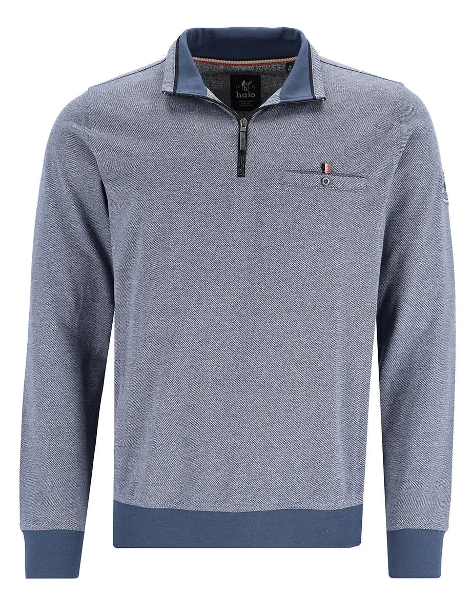 Blauer und grauer strukturierter Pullover mit halbem Reißverschlusskragen, Taschendetails und Kontrastbesatz.