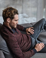 Merlotfarbener marmorierter Pullover mit gerippten Bündchen und Saum, Jeans in dunkler Waschung.