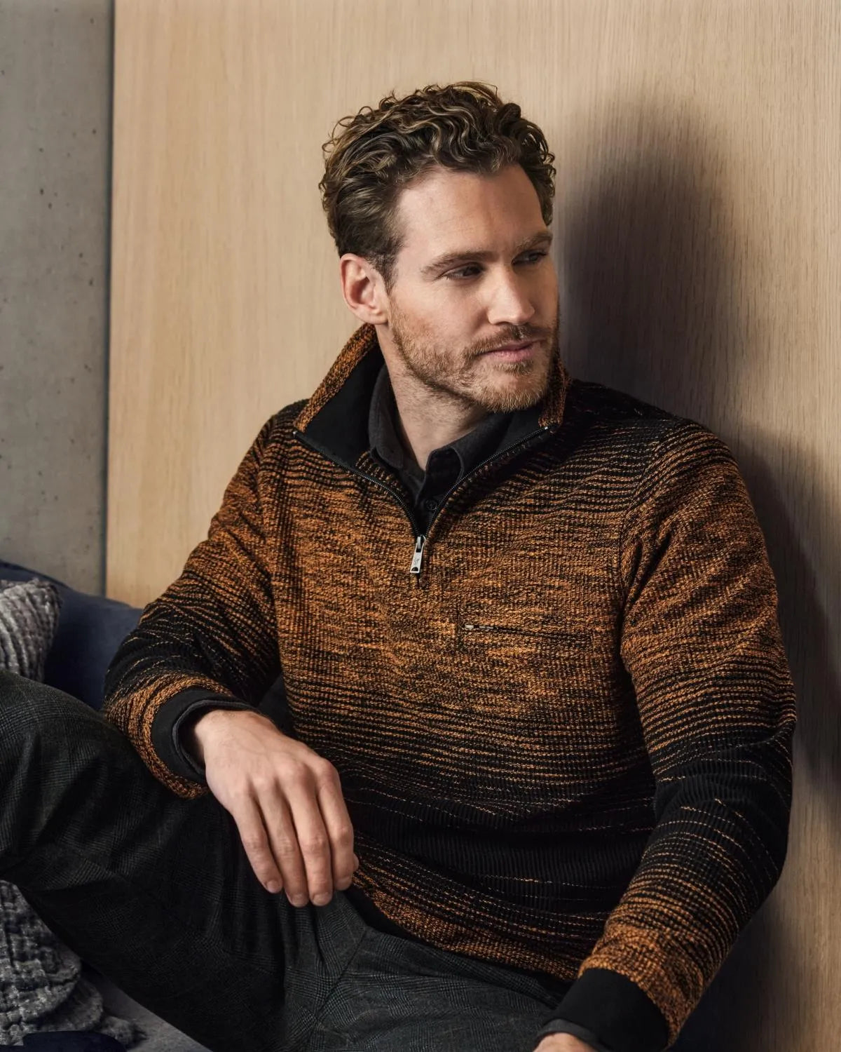 Braun und schwarz gestreifter Pullover mit halbem Reißverschluss, wahrscheinlich aus Wolle oder Acryl.