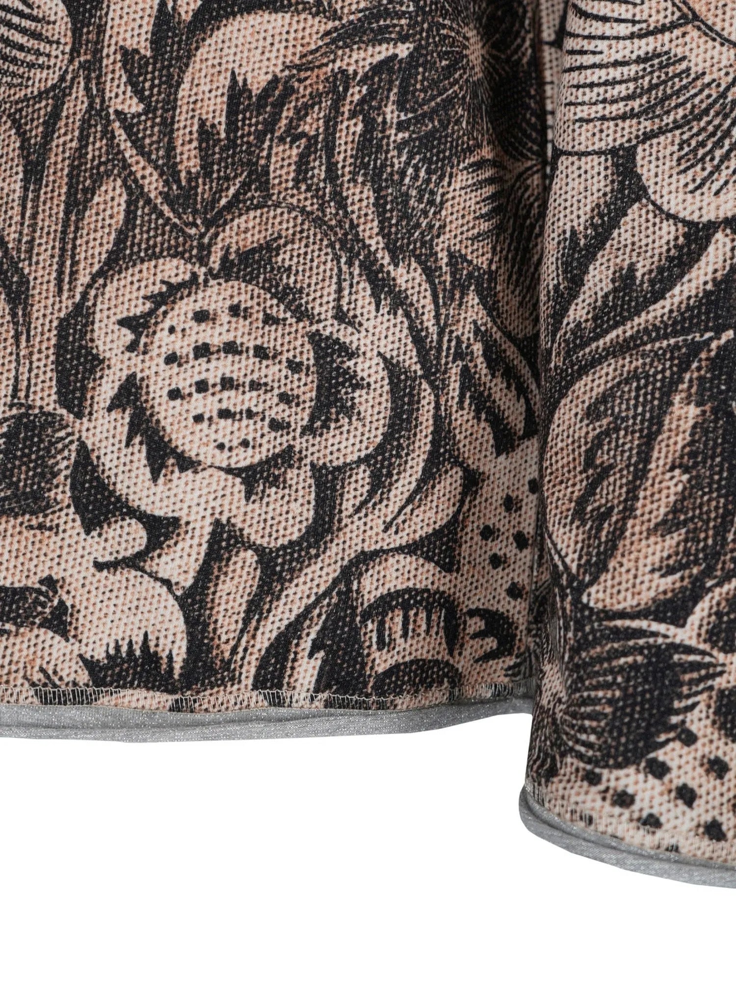 Blumiges Mustergewebe-Kissen mit schwarz-weißem Design auf beigem Hintergrund.