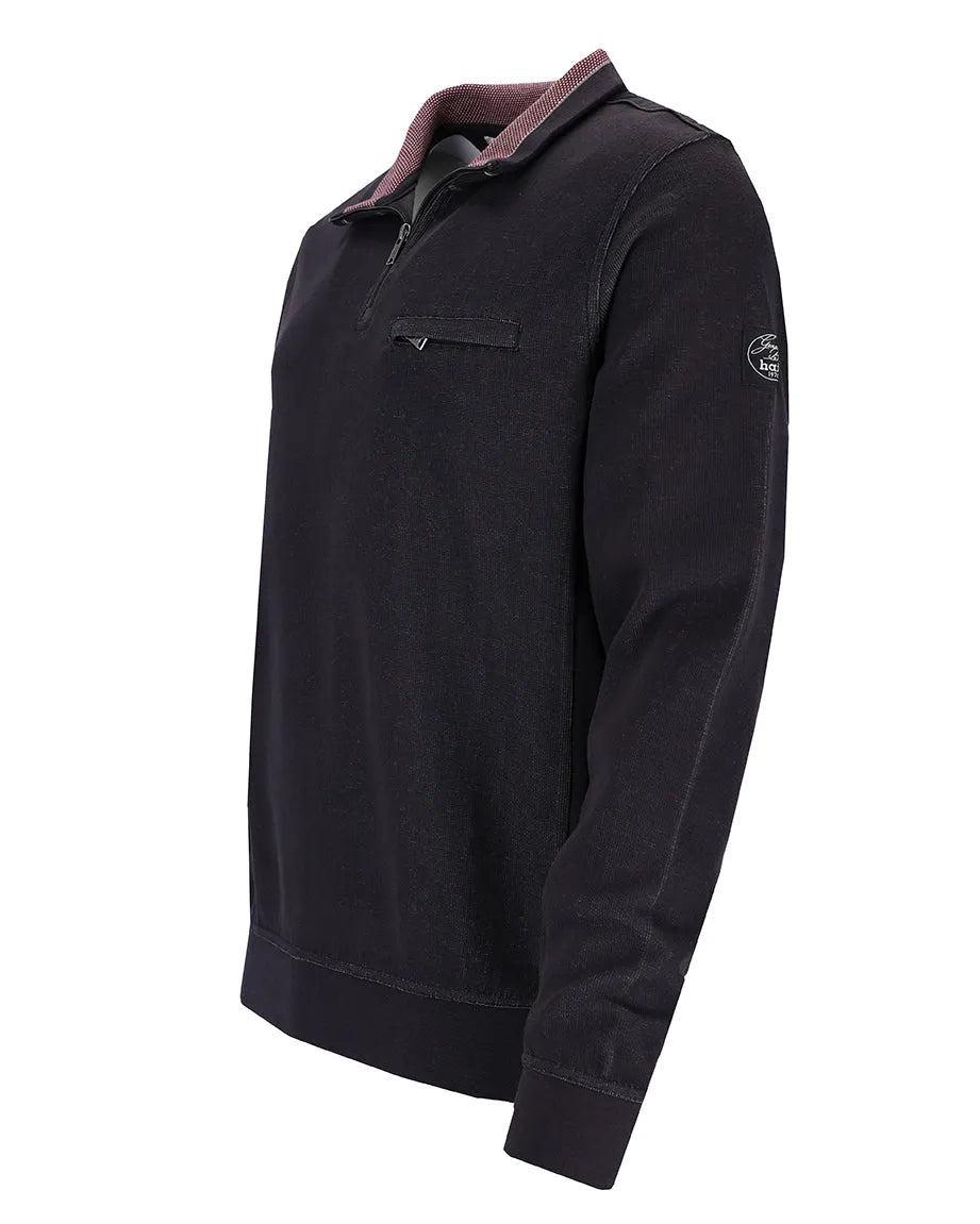 Schwarzer Pullover mit Reißverschluss, lila Akzenten und Logo auf der Brust.