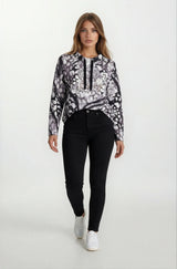 Frau in schwarzem-weiß gemustertem Hoodie mit Floraldesign und Zierbändern