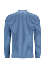 Blauer Zopfstrickpullover mit hohem Halsausschnitt und langen Ärmeln.